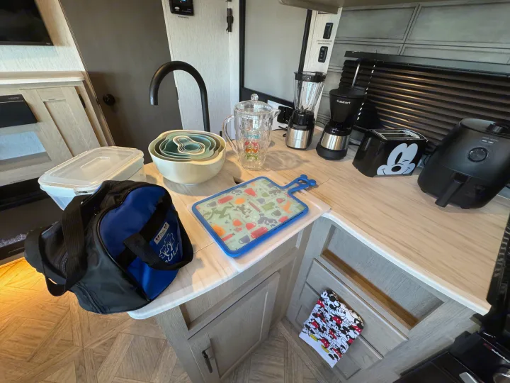 RV rental kitchen counter with a sink, nesting bowls, and small appliances like a Mickey toaster, air fryer, blender.. Forest River Wildwood 2024