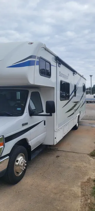 White Class C Sunseeker RV rental parked on concrete under cloudy sky. Ready for your next adventure!. Forest River Sunseeker LE 2020