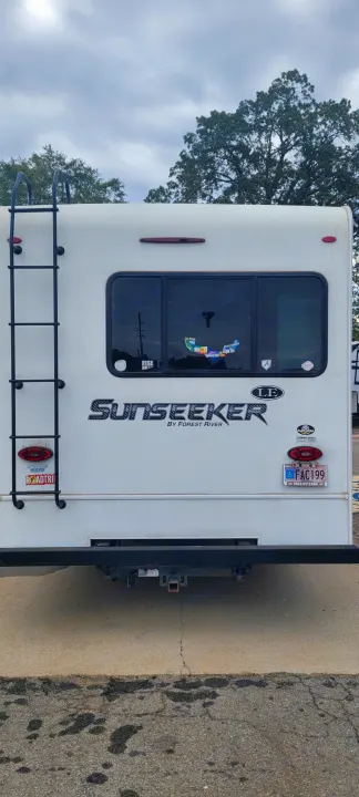 Rear of a white Sunseeker RV, possibly an RV rental, with a ladder, window, and license plates. Perfect for a road trip!. Forest River Sunseeker LE 2020