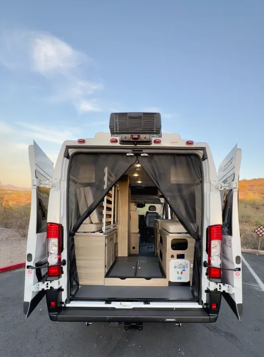 Experience freedom! This RV rental van's open rear reveals a spacious, customized interior for your next road trip adventure.. Winnebago Solis 59PX 2025