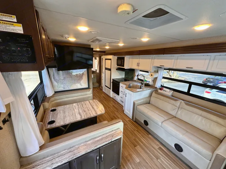 RV rental interior featuring a spacious living area, dinette, and full kitchen, perfect for travel comfort.. Thor A.C.E. 2018