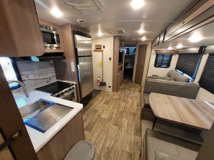 Modern and spacious RV rental interior featuring a full kitchen, dining area, and bunk beds.. Crossroads Sunset Trail Super Lite 2022