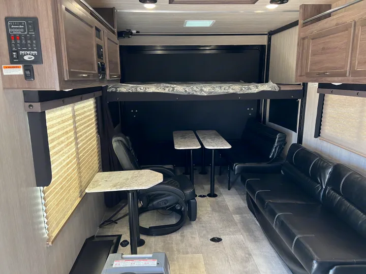 Inside a comfortable **rv rental**: features an overhead bunk, recliners, sofa, and adaptable tables for travel.. Genesis Supreme Rv Genesis Supreme 2022