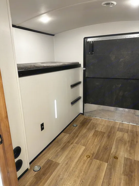 RV rental interior features bunk beds, wood flooring, and a rear ramp door with diamond plate trim, ideal for toy haulers.. Keystone RV Outback Toy Hauler 2023