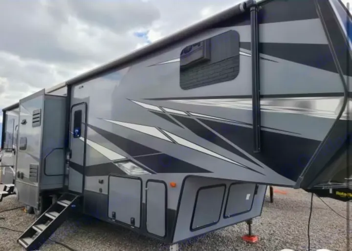 This sleek, modern gray and black fifth-wheel RV rental offers ample space with slide-outs and an awning for adventures.. Keystone Raptor 2021
