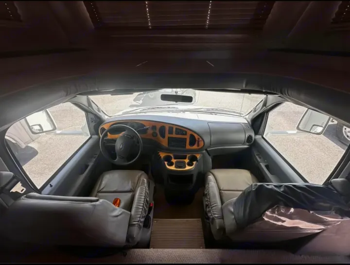 Inside this RV rental, the spacious driver and passenger cockpit features leather seats, a wood-accented dash, and a clear view.. Jayco Granite Ridge 2003