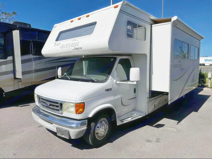 White Jayco Granite Ridge Class C RV with its slide-out deployed. Ideal for an RV rental, offering expanded living space.. Jayco Granite Ridge 2003