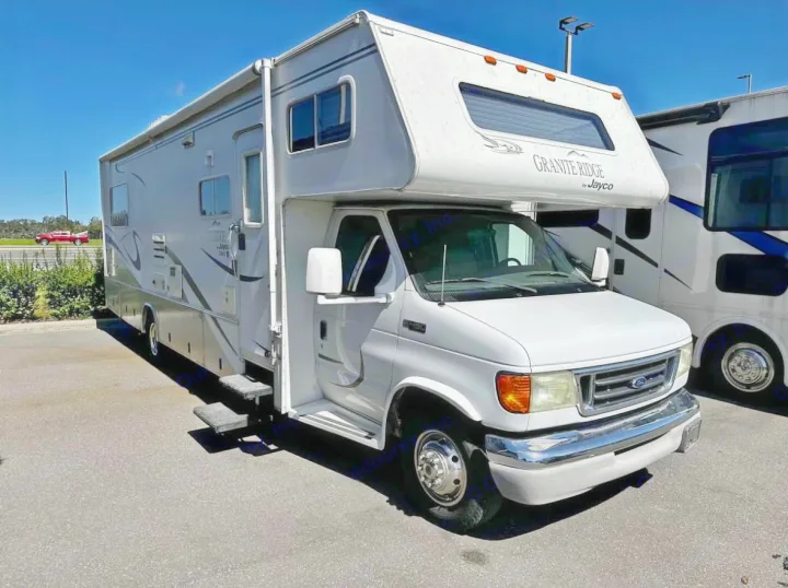 White Jayco Class C motorhome for rv rental, ready for your next road trip adventure. Parked outdoors.. Jayco Granite Ridge 2003