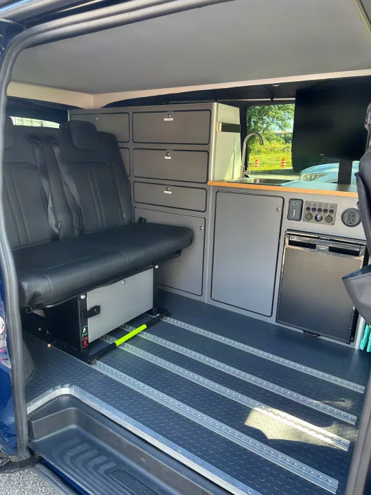 Inside this rv rental, a camper van with versatile rear seating, integrated kitchenette, Dometic fridge, and storage.. Mercedes-Benz Metris 2023