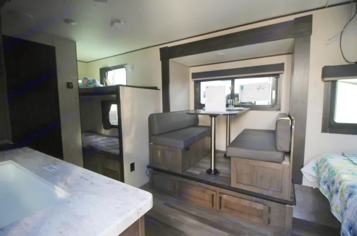 RV rental interior: bunk beds, dinette, kitchen counter, and a bed. Clean, modern, and family-friendly space.. Starcraft Autumn Ridge 180BHS 2023