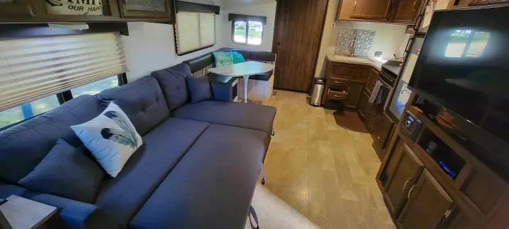 Spacious RV rental with a comfortable gray sectional, dining area, and equipped kitchen. Ready for your adventure.. Coachmen Apex 265rbss 2019