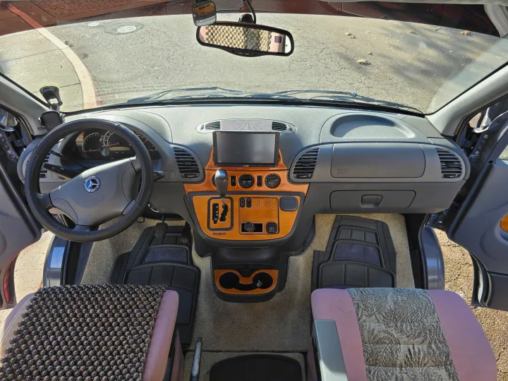 RV rental interior: Mercedes-Benz Sprinter cockpit with dashboard, controls, and seats, ready for adventure.. Leisure Travel Vans Leisure Travel Vans Class B 2005