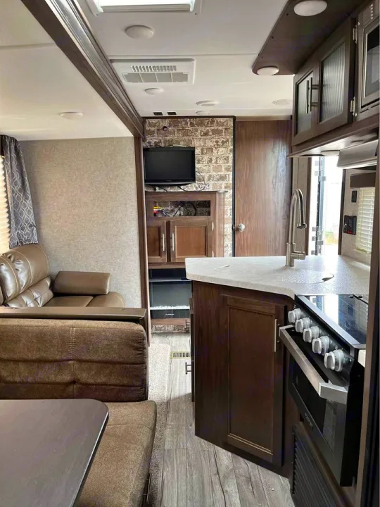 Spacious RV rental interior featuring a modern kitchen, cozy living area with sofa, and dining space. Perfect for your next adventure.. Forest River Cherokee 2018