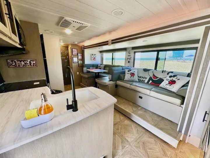 This spacious RV rental features a full kitchen & Mickey Mouse living area, offering incredible beach views right outside!. Forest River Wildwood 2024