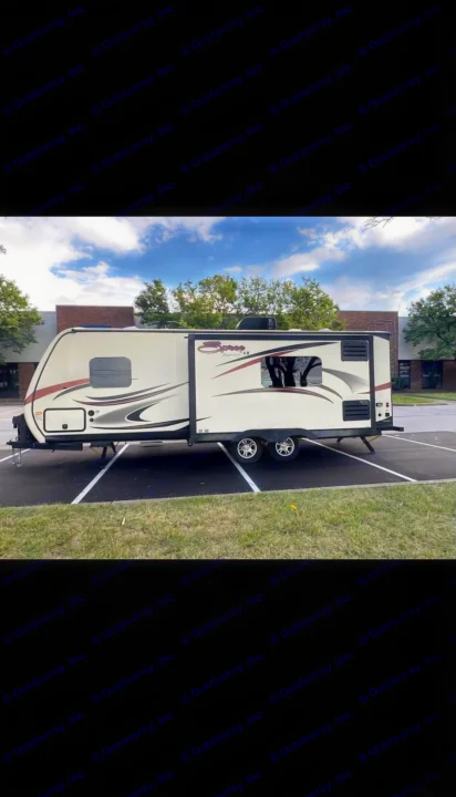 Beige Spreet LX travel trailer for rv rental, parked on asphalt in sunny lot.. KZ Spree 2017
