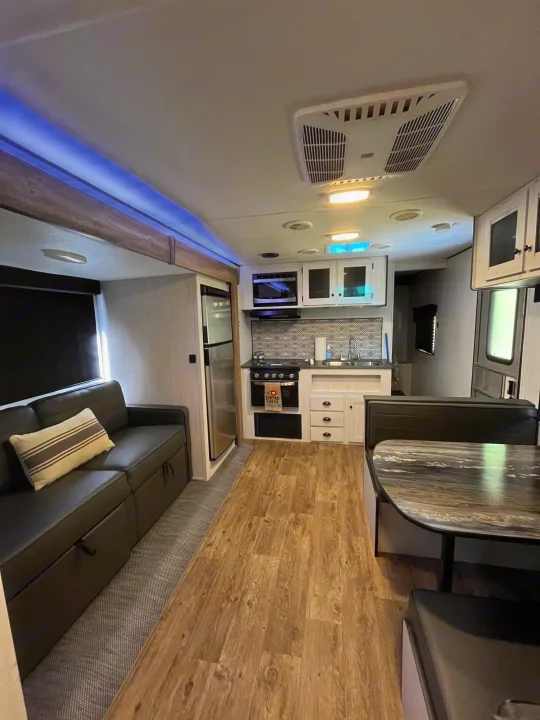 Modern RV rental interior featuring a living, kitchen, and dining area with contemporary design elements.. Heartland RVs Trail Runner 2022