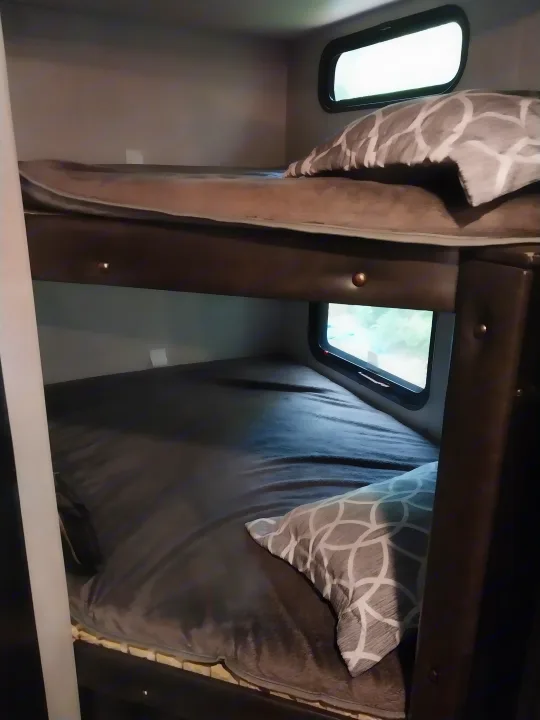 Cozy RV rental bunk beds with windows, perfect for family travel accommodations. Enjoy comfort on the go!. Forest River Cherokee Grey Wolf Black Label 2021