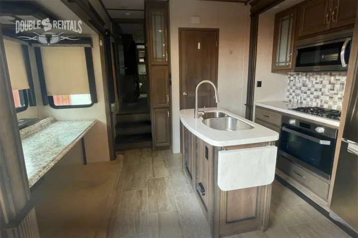 Explore this spacious rv rental! Full kitchen with island, sink, stove, microwave, and ample storage. Modern interior.. Keystone Montana 2019