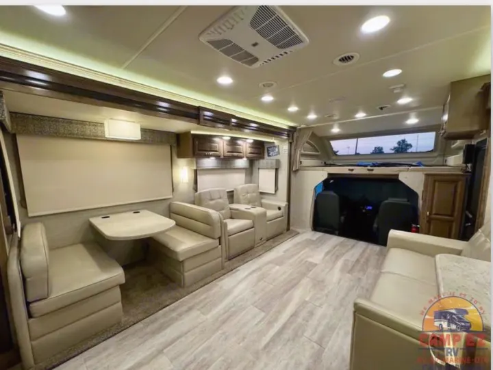 Spacious, modern RV interior with dinette, lounge chairs, and cab-over bed. Ideal for your next RV rental adventure.. Jayco Seneca 2020