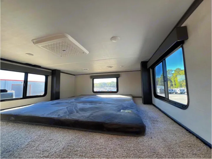 Spacious RV rental bunk area with comfy mattress, multiple windows, and overhead AC.. Keystone Alpine 2025