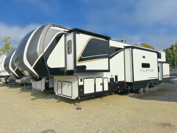 Explore spacious fifth-wheel RV rental options! Multiple modern black and white recreational vehicles with extended slide-outs are parked.. Keystone Alpine 2025