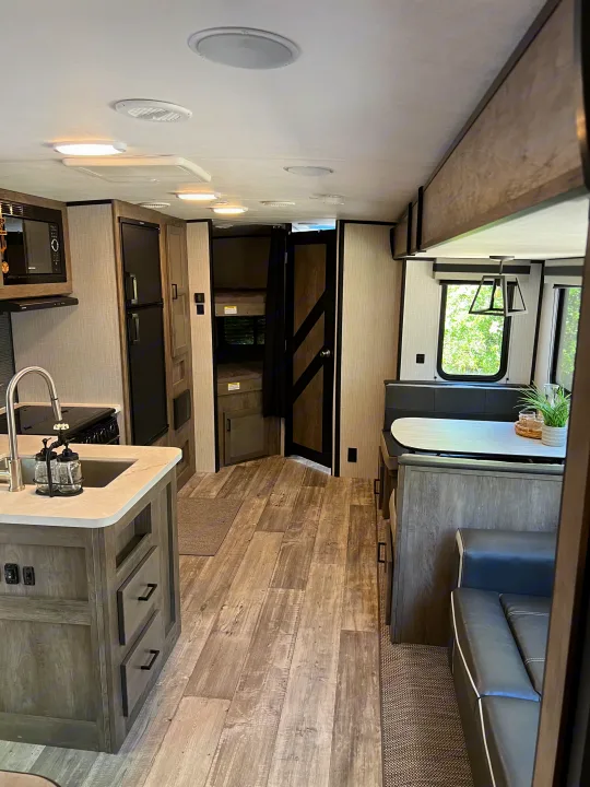 Explore this stylish RV rental interior, featuring a modern kitchen, comfortable dinette, and convenient bunk beds.. Heartland RVs North Trail 2021