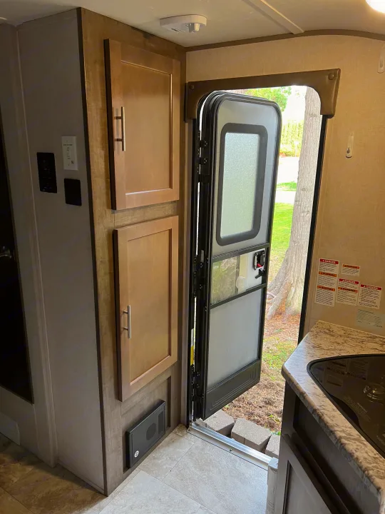 RV rental: Bright interior with open door to nature, showing kitchen counter, cabinetry, and wall controls.. Forest River R-Pod 2018