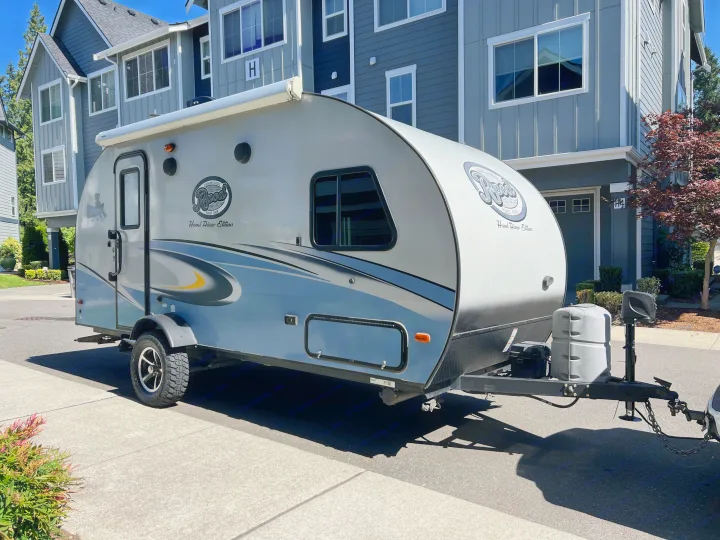 An R-Pod Hood River Edition travel trailer, perfect for an rv rental, parked on a sunny residential street.. Forest River R-Pod 2018