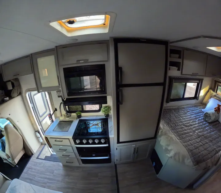 Spacious RV rental interior featuring a modern kitchen, comfortable bedroom, and ample storage, with a skylight.. Thor Coleman 2024