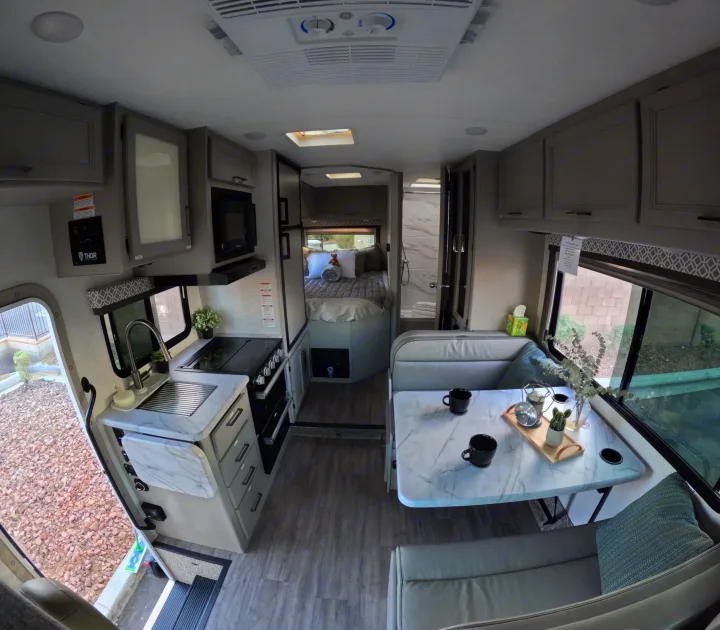 This RV rental's modern interior features a full kitchen, dining nook, and rear bedroom. Perfect for travelers seeking comfort.. Thor Coleman 2024
