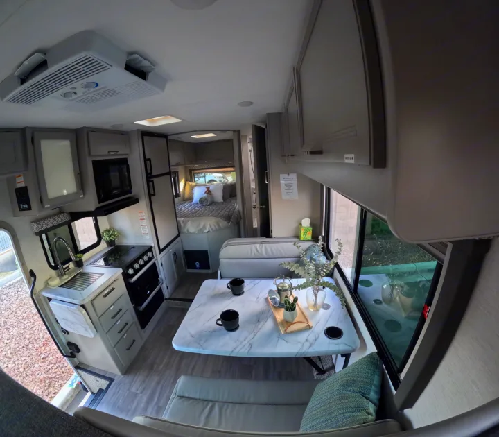 Spacious RV rental interior featuring a full kitchen, dining area, and comfortable bedroom for road trips.. Thor Coleman 2024