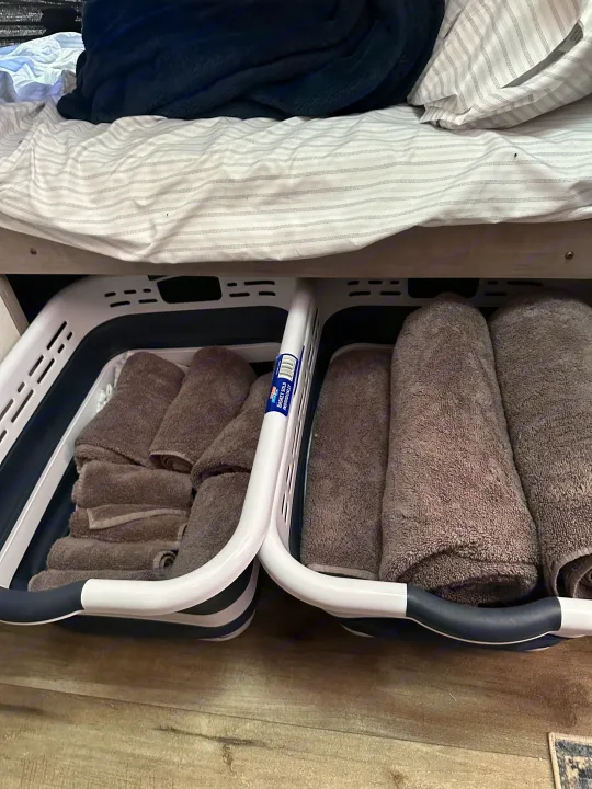 Efficient RV rental storage: Gray towels neatly organized in under-bed collapsible baskets, maximizing space.. Coleman Lantern 17b 2024