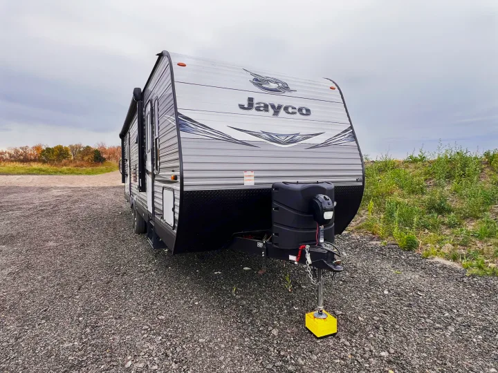 Jayco travel trailer on a gravel lot, available for RV rental.. Jayco Jayflight 2021