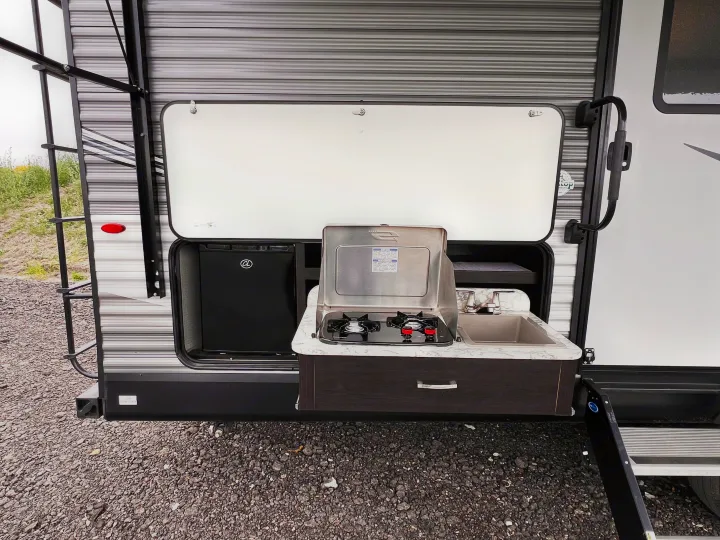 RV rental with an exterior kitchen: mini-fridge, two-burner stove, and sink. Ideal for convenient outdoor cooking and camping.. Jayco Jayflight 2021