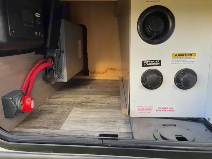 RV rental compartment: power inverter, battery disconnect, and winterized water hookups.. Crossroads Sunset Trail Super Lite 2022