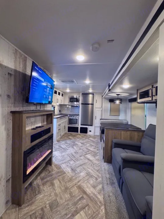 This RV rental showcases a modern, well-equipped interior with a kitchen, living area, and dining booth.. Palomino Puma 2023