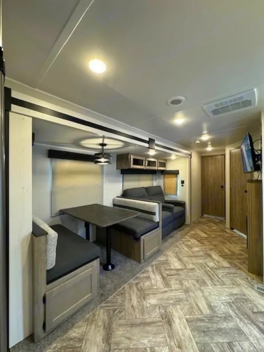 Spacious RV rental interior featuring a comfortable dinette, sofa, and modern decor, ideal for travel adventures.. Palomino Puma 2023