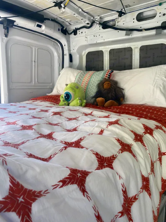 Comfortable camper van bed in an RV rental, featuring playful plush toys & sound-dampened walls.. FORD Ford Transit 2015