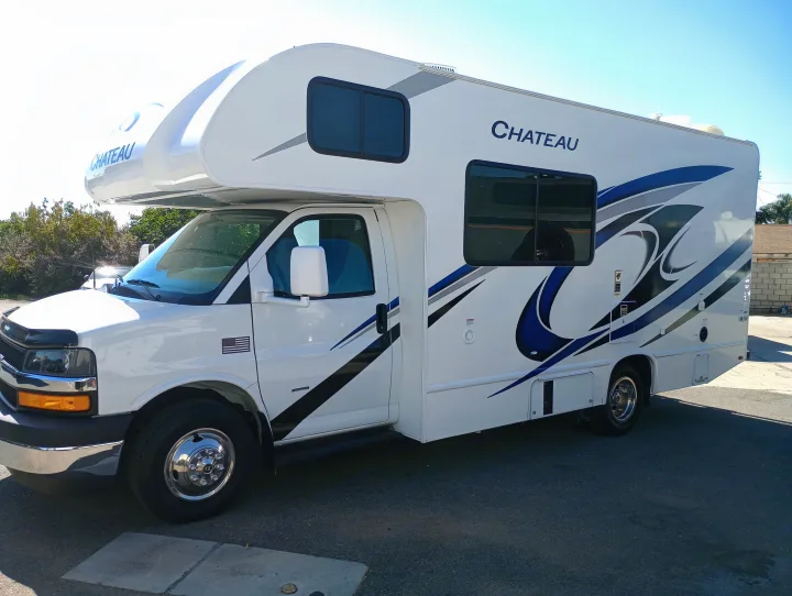 Spacious white Thor Chateau Class C RV for rent, showcasing blue and grey exterior graphics.. Thor Chateau 2022