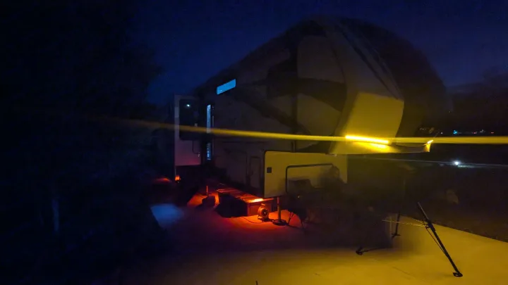 Fifth wheel RV rental illuminated at night with vibrant yellow, red, and blue under-lighting. Ideal for camping.. K-Z Manufacturing Venom V3411TK 2020