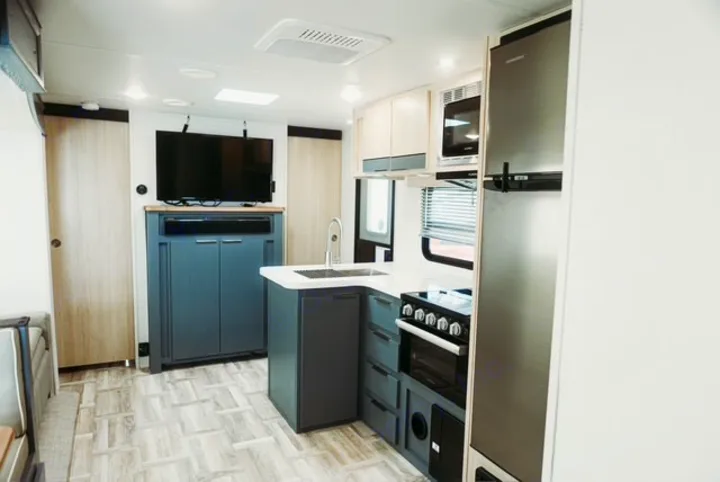 Modern RV interior featuring a full kitchen, living area with TV, and compact storage, perfect for your next RV rental.. Forest River Tracer 2024