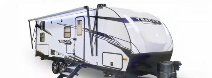 A modern white and black Tracer travel trailer, with its awning extended, perfect for your next RV rental adventure.. Forest River Tracer 2024