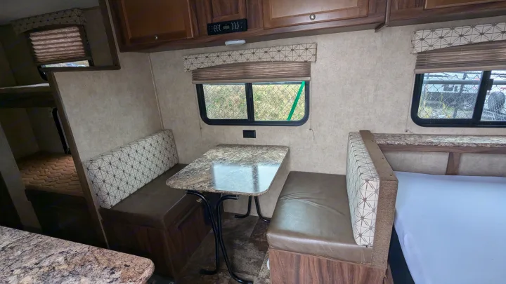 Cozy RV rental interior: dinette seating, bunk beds, and a main sleeping area. Ideal for your next road trip adventure.. Coachmen Viking 2017