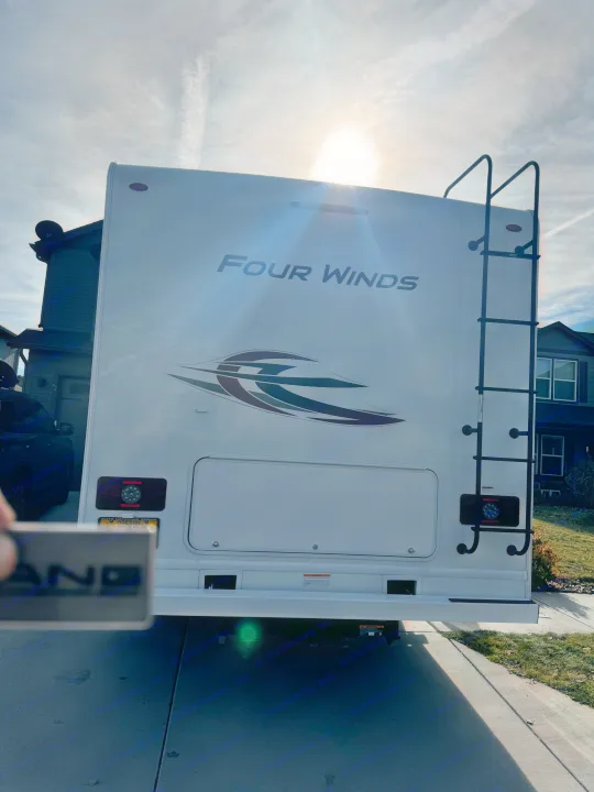 Bright white Four Winds RV rear, with ladder and Oregon plate, parked on a sunny day. Ideal for an RV rental.. Thor Motor Coach Four Winds 2022