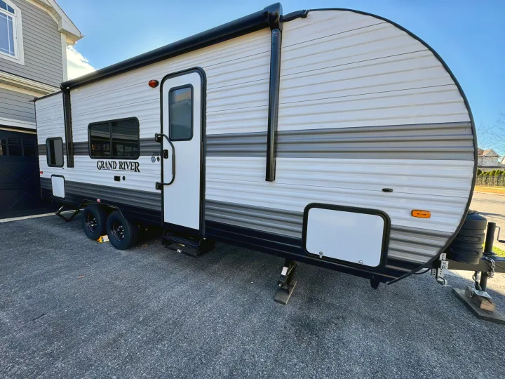Light gray Grand River travel trailer (RV rental) on a driveway, ready for adventure.. Grand River 25BH 2025