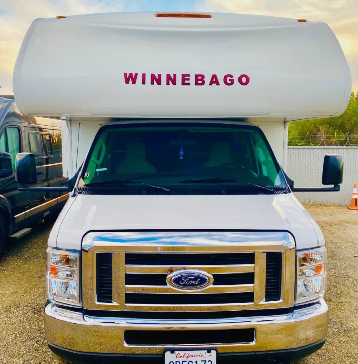 Front view of a white Winnebago Class C RV on a Ford chassis, ready for your next rv rental adventure.. Winnebago 25 2019