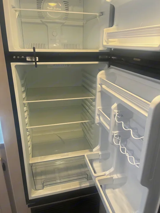 Empty and clean RV rental fridge ready for your adventure. Top freezer, adjustable shelves, and door bins.. Heartland RVs Prowler Lynx 302 BHX 2025