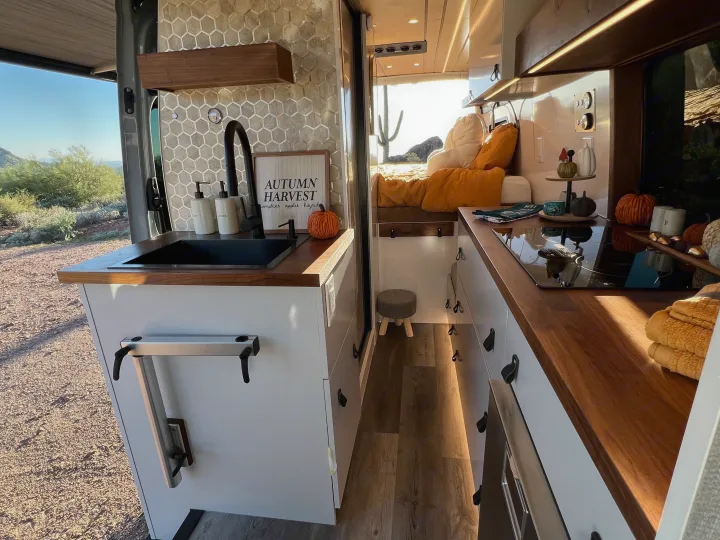 Inside a cozy RV rental: kitchen, bed, and a scenic desert view. Perfect camper van living.. Mercedes Sprinter Van 170 4x4 2022