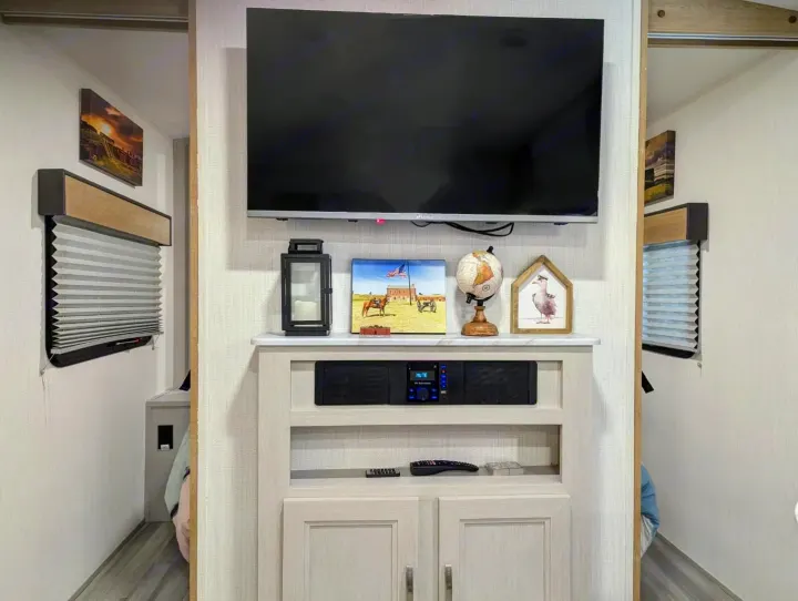 Full view of an RV rental's central entertainment unit with TV & stereo, flanked by hallways leading to rooms.. Cruiser Rv Corp Other 2024