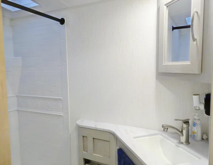 RV rental bathroom: modern, clean interior with white shower, vanity sink, and mirrored cabinet. Bright and functional design.. Cruiser Rv Corp Other 2024